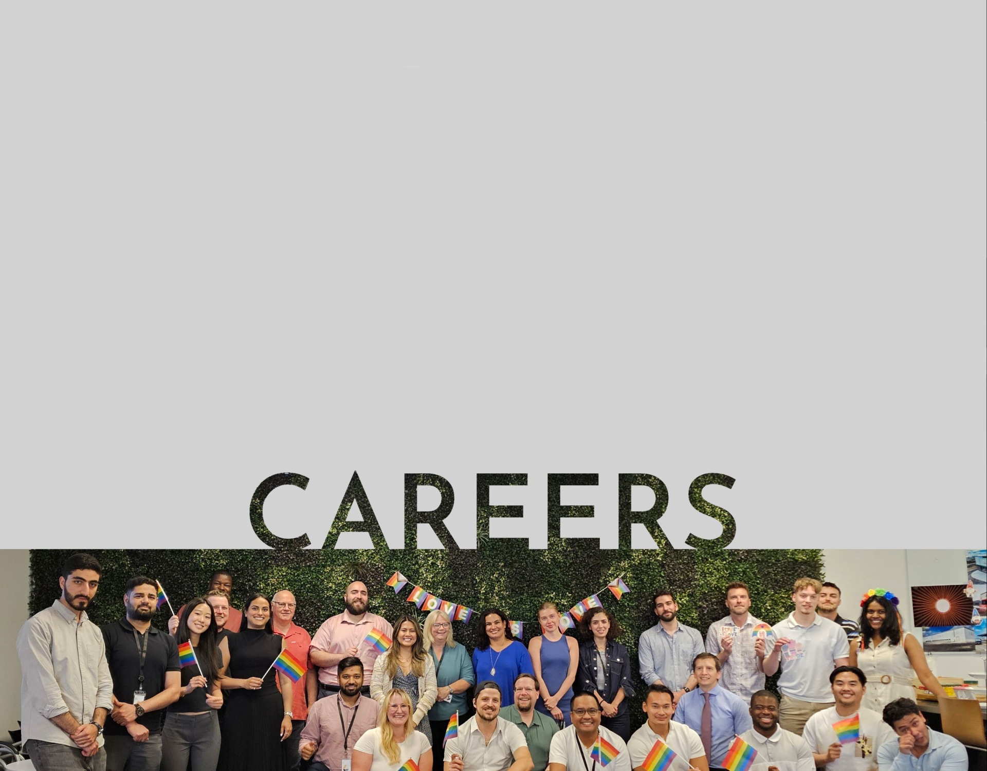 The word “CAREERS” appears across the top of the image, overlaid on a wide group photo of employees gathered indoors near a decorated holiday tree, with glass walls and evening city lights in the background.