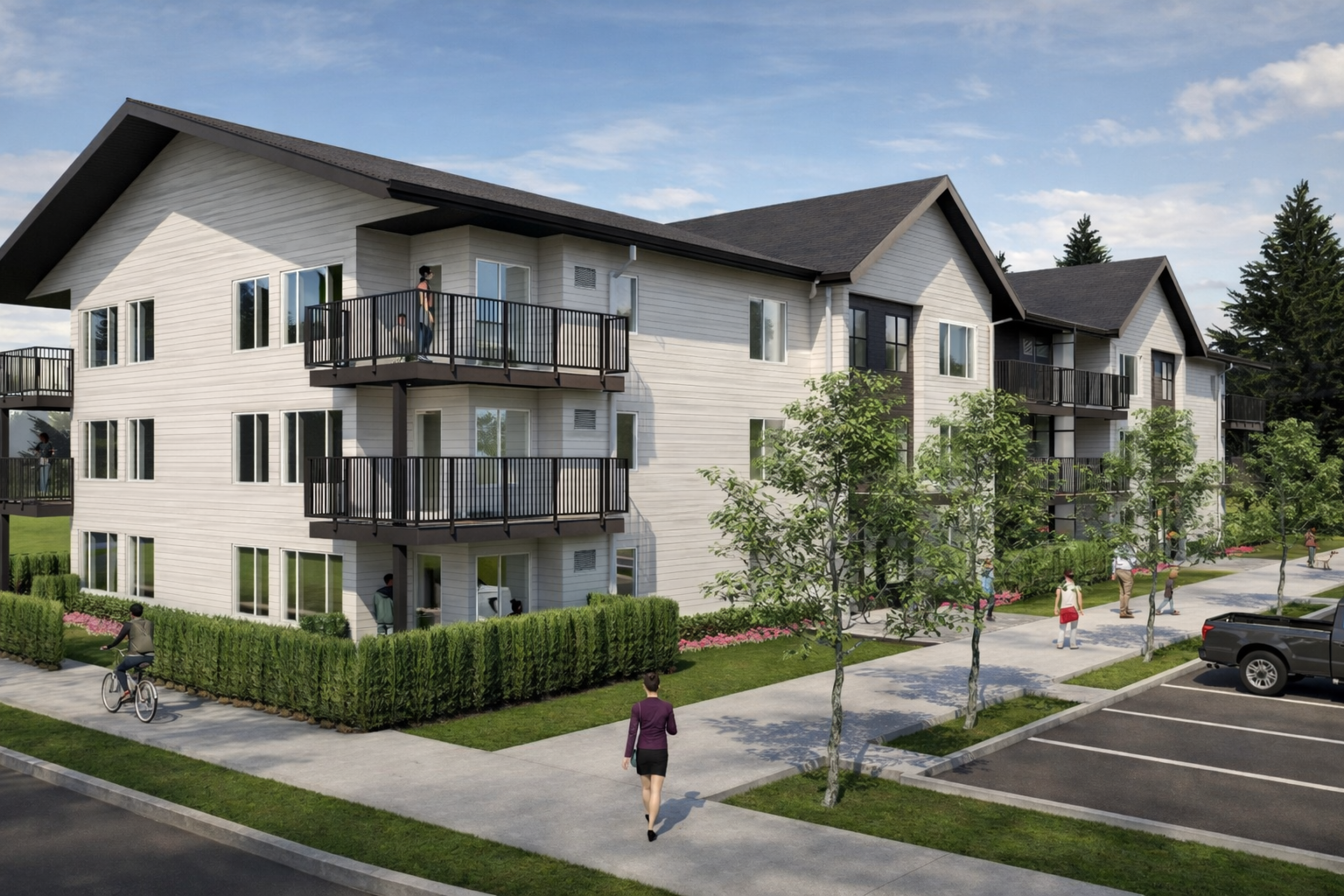 A rendered view of a three‑storey residential apartment building with light exterior siding and dark roofs, featuring multiple balconies along both sides. Landscaped sidewalks, trees, parking spaces, and people walking and cycling line the street und